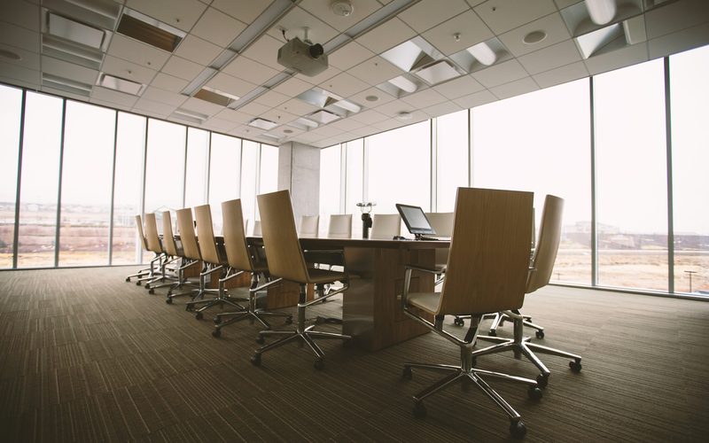 An empty boardroom table and chairs in soft daylight
